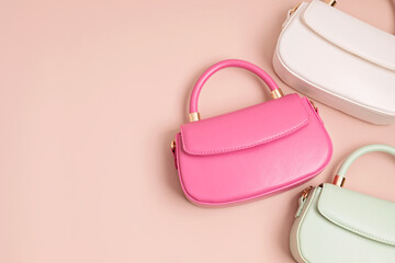 Three pastel colored womens hand bags on pink background. Summer fashion concept