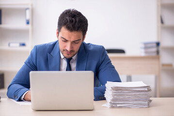 Young male employee and too much work in the office