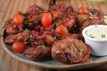 fried chicken with tomatoes and caramelized onions wings with herb sauce