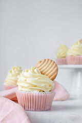 Pink cupcakes with tall american buttercream swirl and cookie garnish, cupcakes in pink liners with a tall vanilla buttercream and a cookie, birthday cupcakes on a white background