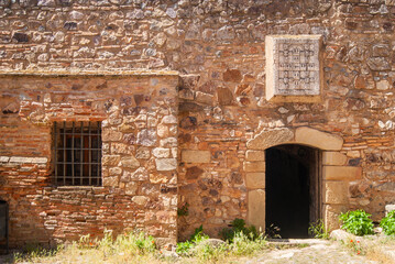 Fototapeta na wymiar Fachada medieval de piedra con ventana enrejada.