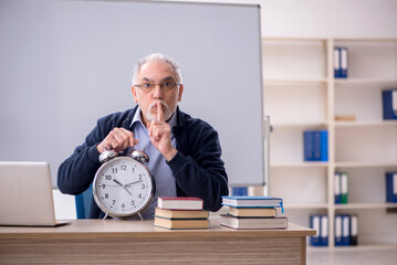 Old male teacher in time management concept