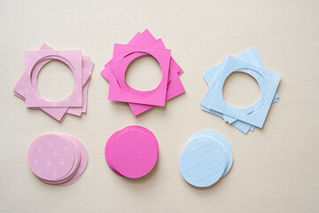piles of square shapes with circle cutouts and corresponding piles of paper discs on blank paper