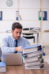 Young male employee and too much work in the office