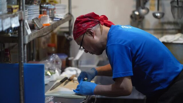 	捌いた魚の小骨を抜く男性