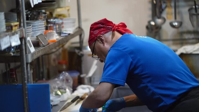 	捌いた魚の小骨を抜く男性