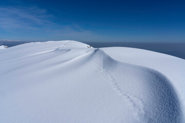 snowdrifts on top of the alpine mountain. snow dune lines, texture and shapes background