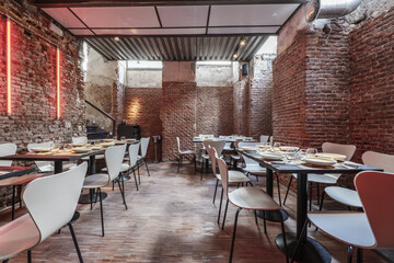 Room of a restaurant with brick walls without rendering with Wooden dining tables