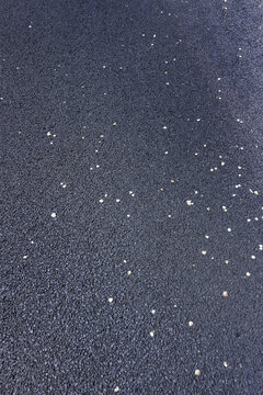 A tarred surface of a road with flower petals