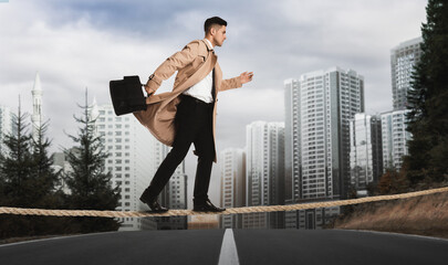 Risks and challenges of entrepreneurship. Concentrated businessman with portfolio crossing road on rope outdoors