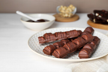 Tasty chocolate bars on white wooden table, space for text
