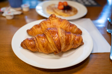 Two fresh baked puff croissants, traditional French breakfast