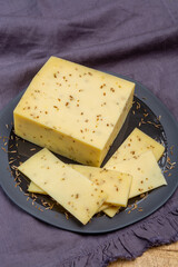 Cheese collection, piece of cow milk Dutch gouda cheese with dried aromatic cumin seeds close up