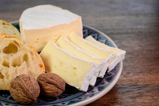 Lunch with fresh baguette and French white mold soft cow milk cheese Caprice des Dieux from Haute-Marne region, France