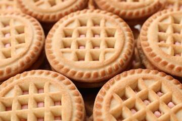 Tasty sandwich cookies with cream as background, closeup