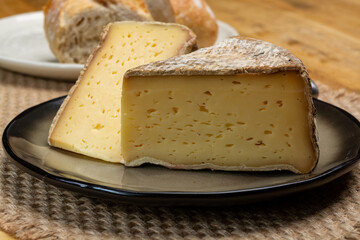 Pieces of cheese tomme de montagne or tomme de savoie made from cow milk in French Alps close up
