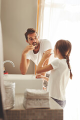 Brushing teeth, father and child learn in a bathroom at home in morning with dental cleaning. Oral...