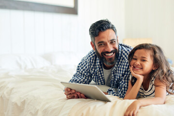 Happy, portrait and digital tablet by girl with father on a bed, relax and browsing for...