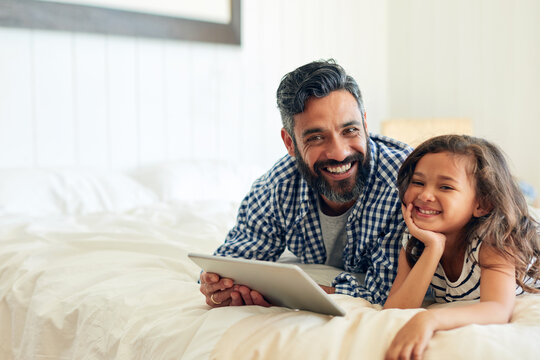 Happy, Portrait And Digital Tablet By Girl With Father On A Bed, Relax And Browsing For Entertainment In Their Home. Face, Smile And Parent And With Child In Bedroom Online For Streaming Or Reading