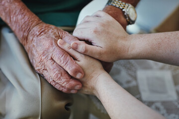 Elderly man, woman and holding hands for support with care and empathy while together for closeup....