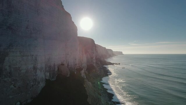 Aerial of impressive Normandy's white cliffs, round pebbles beaches and green pasture on the Alabaster Coast, France, 4K drone
