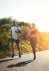 Freedom, running and happy with couple in road for workout, cardio performance and summer. Marathon, exercise and teamwork with black man and woman runner in nature for sports, training and race