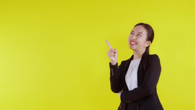 Portrait happy young asian business woman presenting isolated on yellow background, advertising and marketing, executive and manager, businesswoman confident showing and talking with expression.
