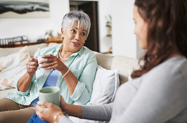 Happy, coffee and mother with daughter on sofa in living room for bonding, conversation and happiness. Smile, chat and discussion with women talking in family home for generations, reunion and break