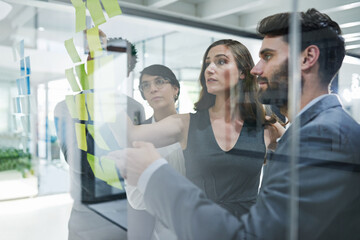 Glass wall, teamwork and business people planning, strategy and brainstorming in office workplace....