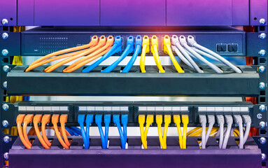 colorful network cables connected on network switches panel in data center