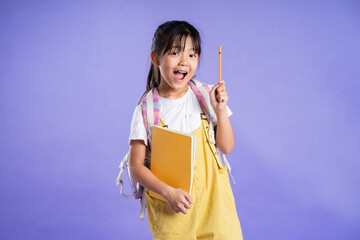 cute asian schoolgirl posing on purple background