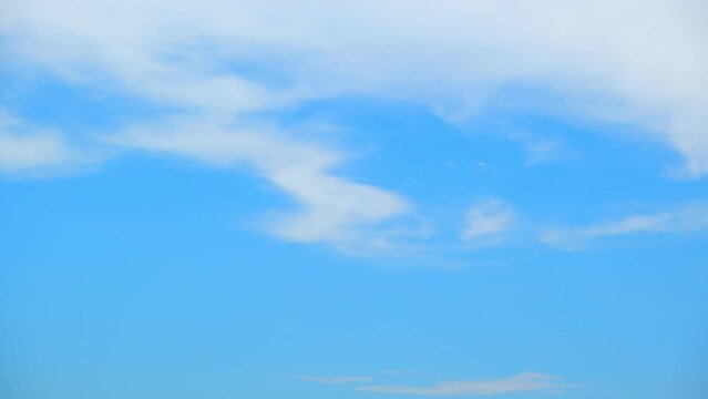 Timelapse showcases a blue sky adorned with billowing, ever-changing clouds. While the clouds dance across the frame, forming a myriad of patterns that enthrall and inspire wonder. Time-lapse. 4K UHD
