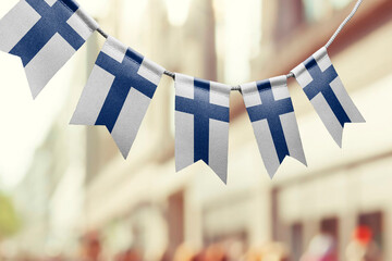 A garland of Finland national flags on an abstract blurred background