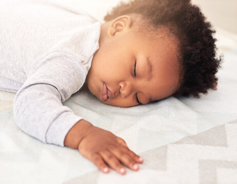 Baby, african boy and sleep in bedroom for rest, health and peace for growth, development and relax in family home. Black male infant, tired and sleeping on bed with fatigue, quiet and calm in house