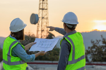Professional team Engineer managers workers working outdoors with telecommunication antenna and sunset background. - obrazy, fototapety, plakaty