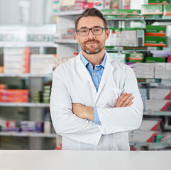 Success, crossed arms and portrait of pharmacist in pharmacy clinic standing with confidence. Healthcare, medical and mature male chemist by the counter of pharmaceutical medication store dispensary.