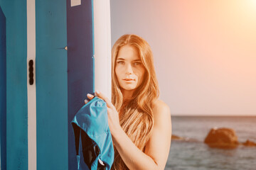 Woman sea sup. Close up portrait of happy young caucasian woman with long hair looking at camera...