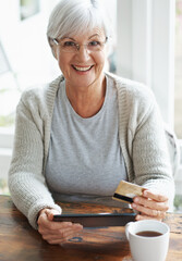 Happy senior woman, tablet and credit card for online shopping, payment or banking on table at...