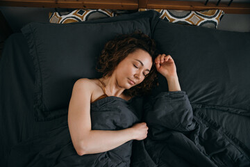 Beautiful young woman sleeps in bed in the early morning