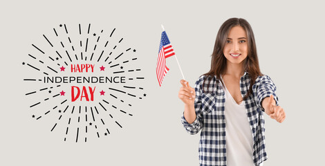 Young woman with USA flag and text HAPPY INDEPENDENCE DAY on light background - obrazy, fototapety, plakaty