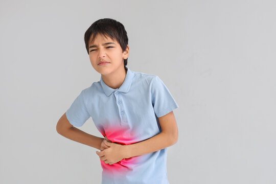 Little boy suffering from appendicitis on light background