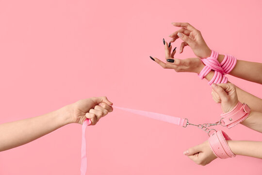 Women with sex toys on pink background
