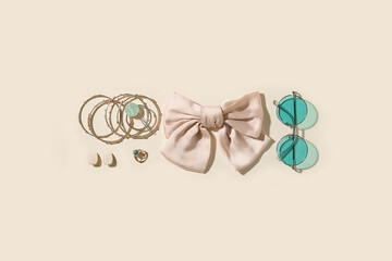 Stylish jewelry with sunglasses on light background