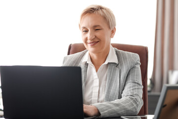 Mature businesswoman using laptop in office