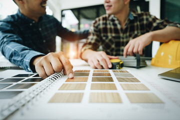 Engineers, designers and interior designers are finalizing the design of interiors by discussing selecting materials and colors to design rooms to present to clients.
