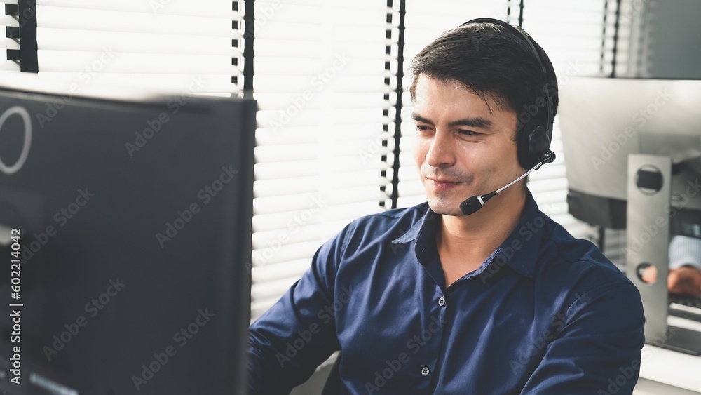 Aufkleber young competent asian male call center agent working at his computer while simultaneously speaking w