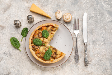 Fototapeta na wymiar Mushroom pie with spinach leaves and cutlery on white grunge table