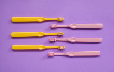 Plastic toothbrushes on lilac background