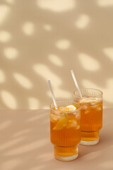 Glasses of cold tea, ice cubes, lemon slices and a sprig of mint. Cooling summer drinks. Copy space