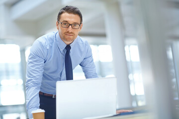 Fototapeta premium Portrait, laptop and mission with a businessman working on research in his office for a report. Computer, mindset and vision with a male employee working on innovation or planning for success